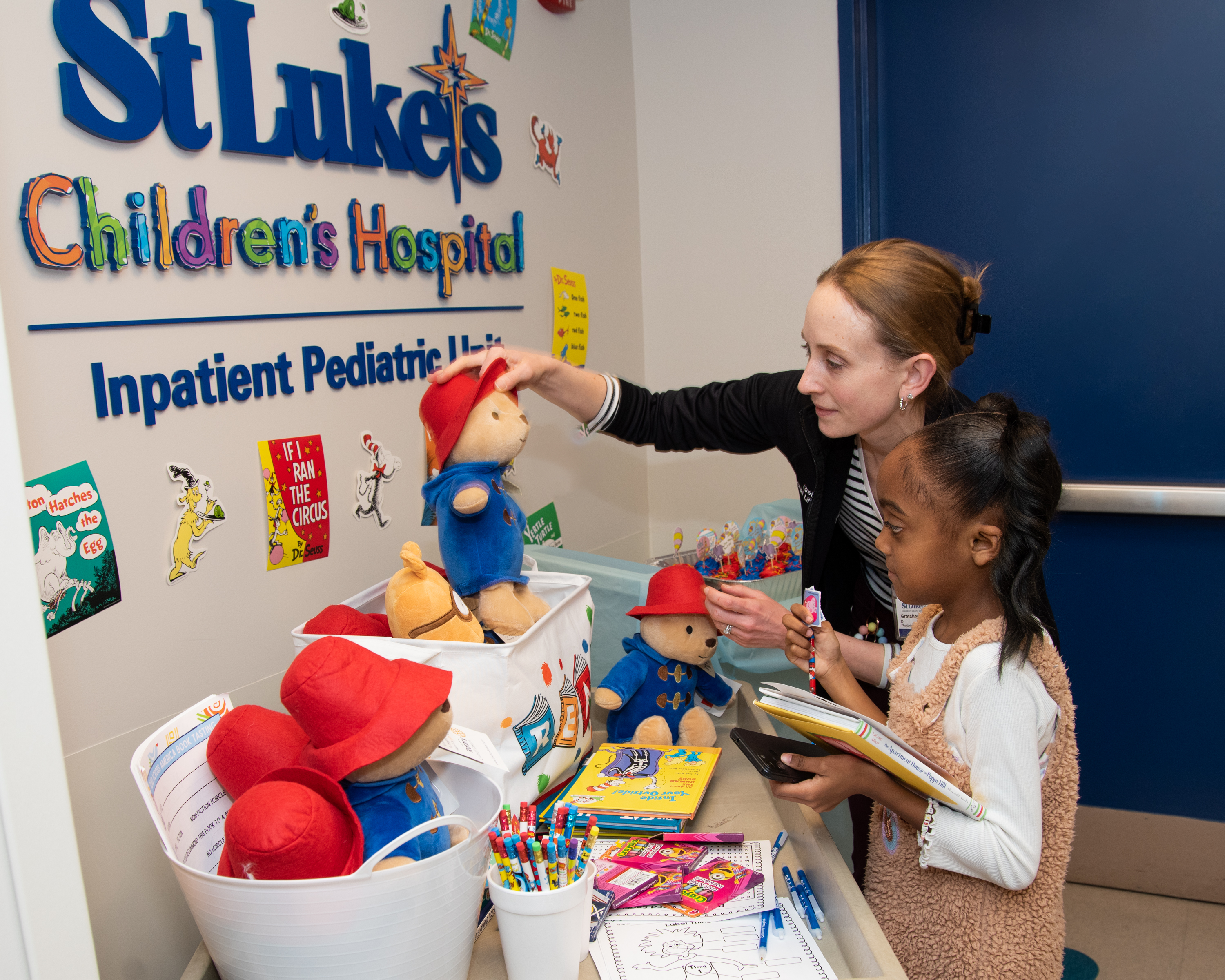 Gretchen Duffy, Coordinator for Child Life Services, helps Leah Correa Cora of Bethlehem choose a book and stuffed animal